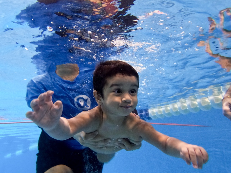 A boy diving underwater towards the camera