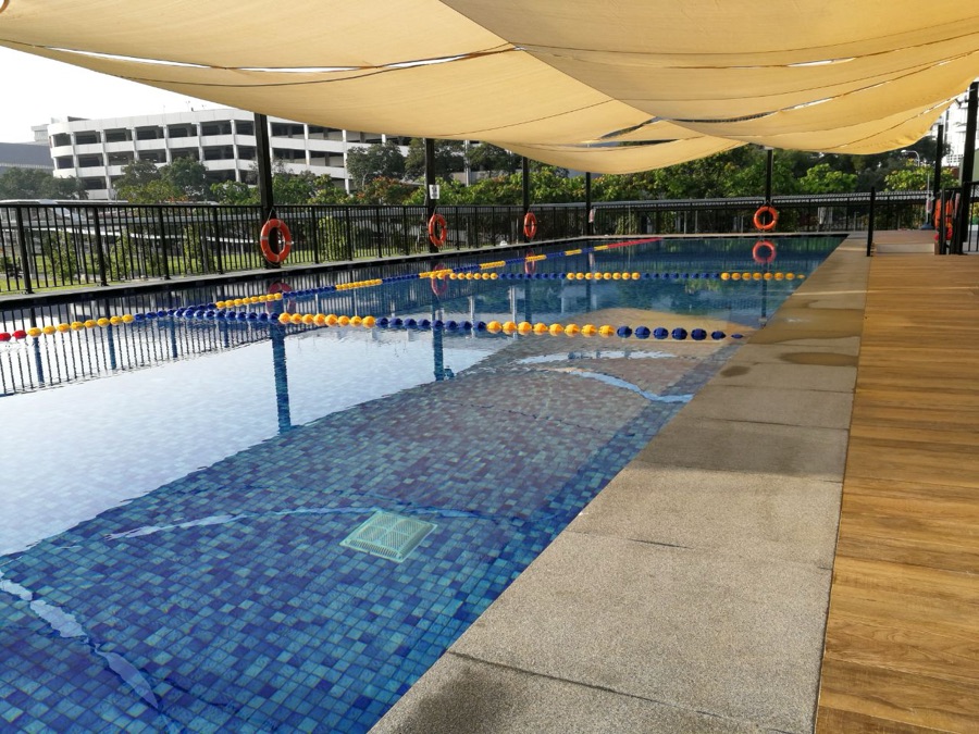 An outdoor lane pool at Happy Fish Jurong East under a shade sail
